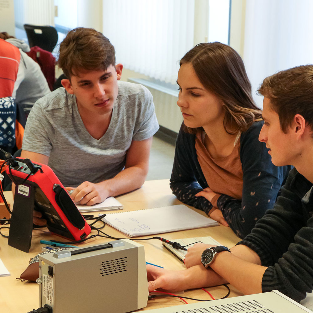 Studierende untersuchen elektrische Schaltkreise mit einem Oszilloskop.