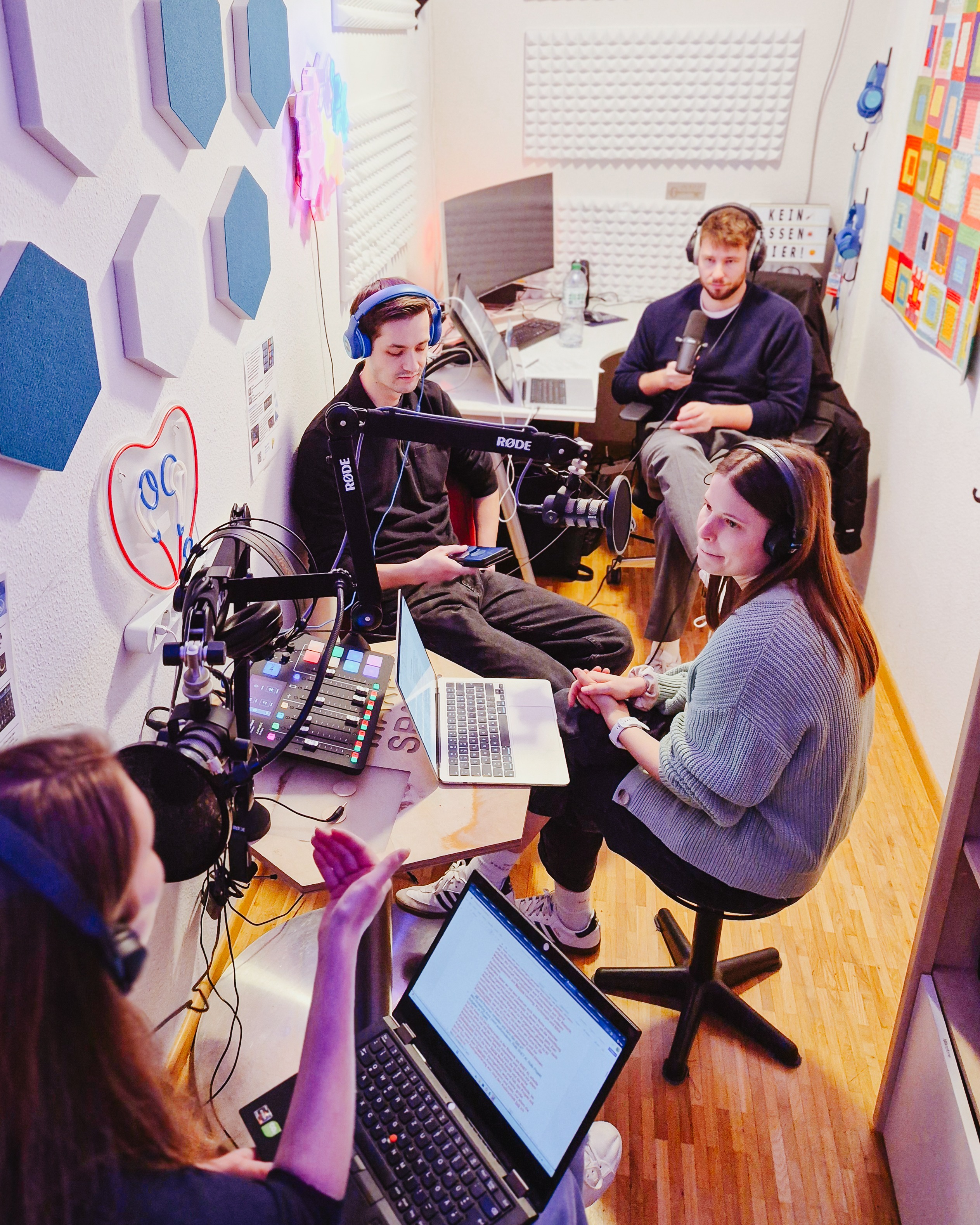 Vier Personen in einem Podcast-Aufnahmestudio