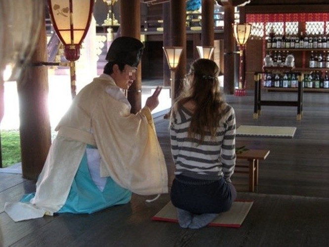 Ein Shinto-Priester erläutert einer TCJS-Studentin den Ablauf einer Shinto-Zeremonie