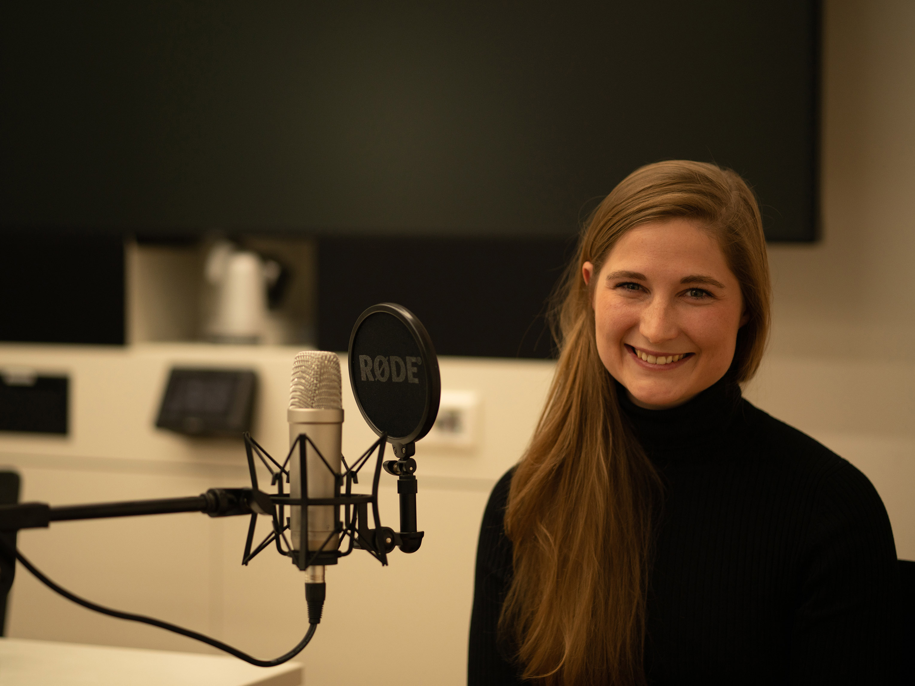Auguste Schulz sitting in a studio with a microphone in front of her