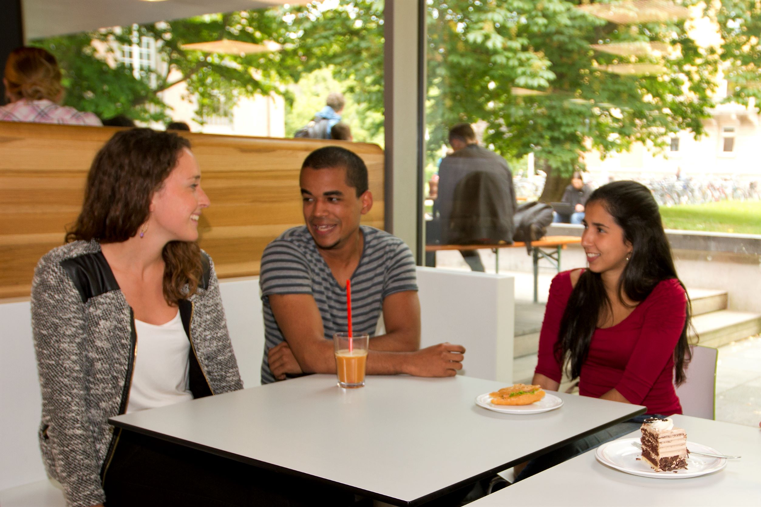 3 Studierende sitzen bei einem Kaffee in der Cafeteria