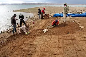 Die Lehmziegel der bronzezeitlichen Gebäude sind vom Wasser des Stausees durchnässt, lassen sich aber dennoch erkennen und von den Projektbeteiligten freilegen