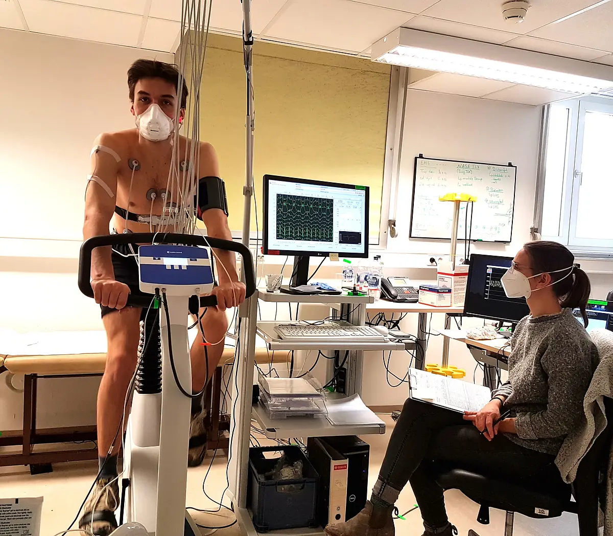 Test subject rides a bicycle while being medically monitored.