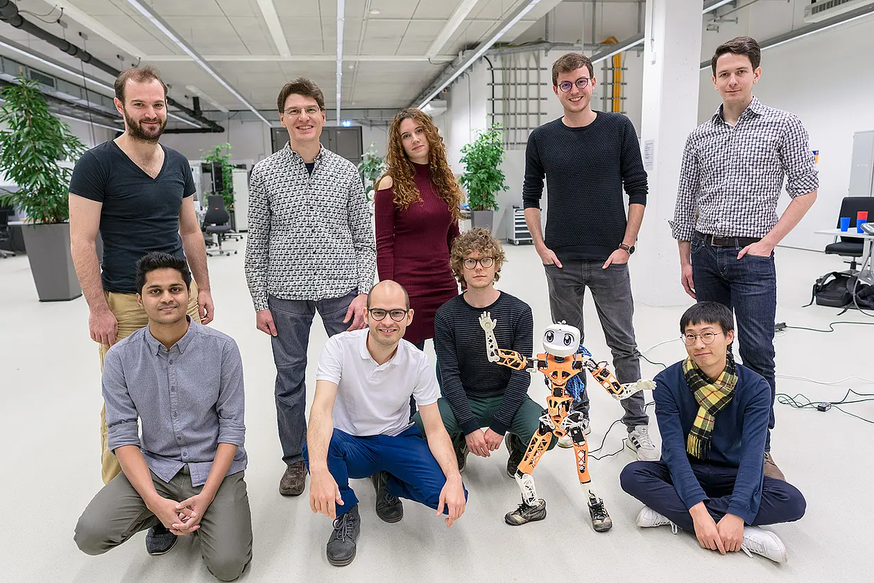 The Autonomous Learning Group team posing with their robot Poppy.