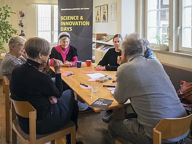 TeilnehmerInnen am Tisch im Gespräch