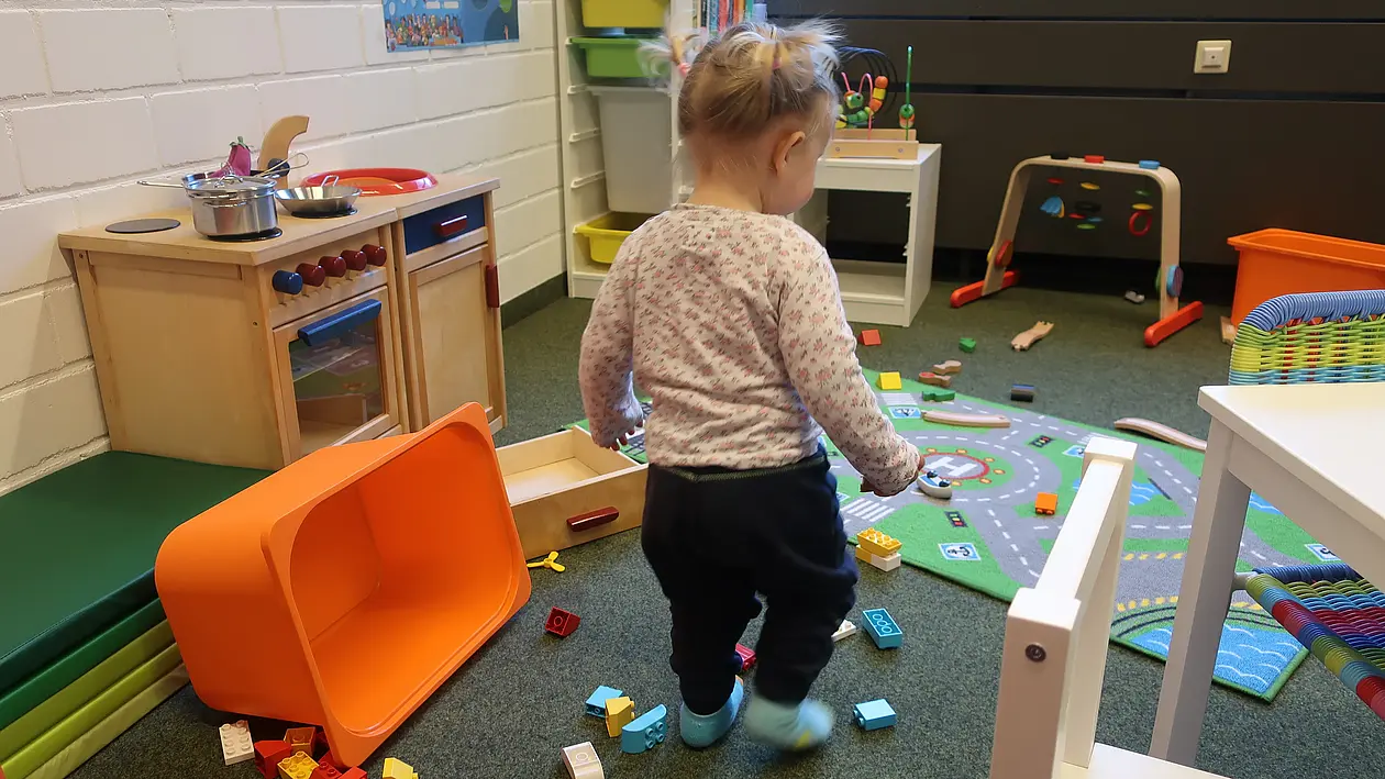Kachel zeigt ein Kleinkind in einem Spielzimmer der Universität  (verlinkt mit Angebot Kinderbetreuung)