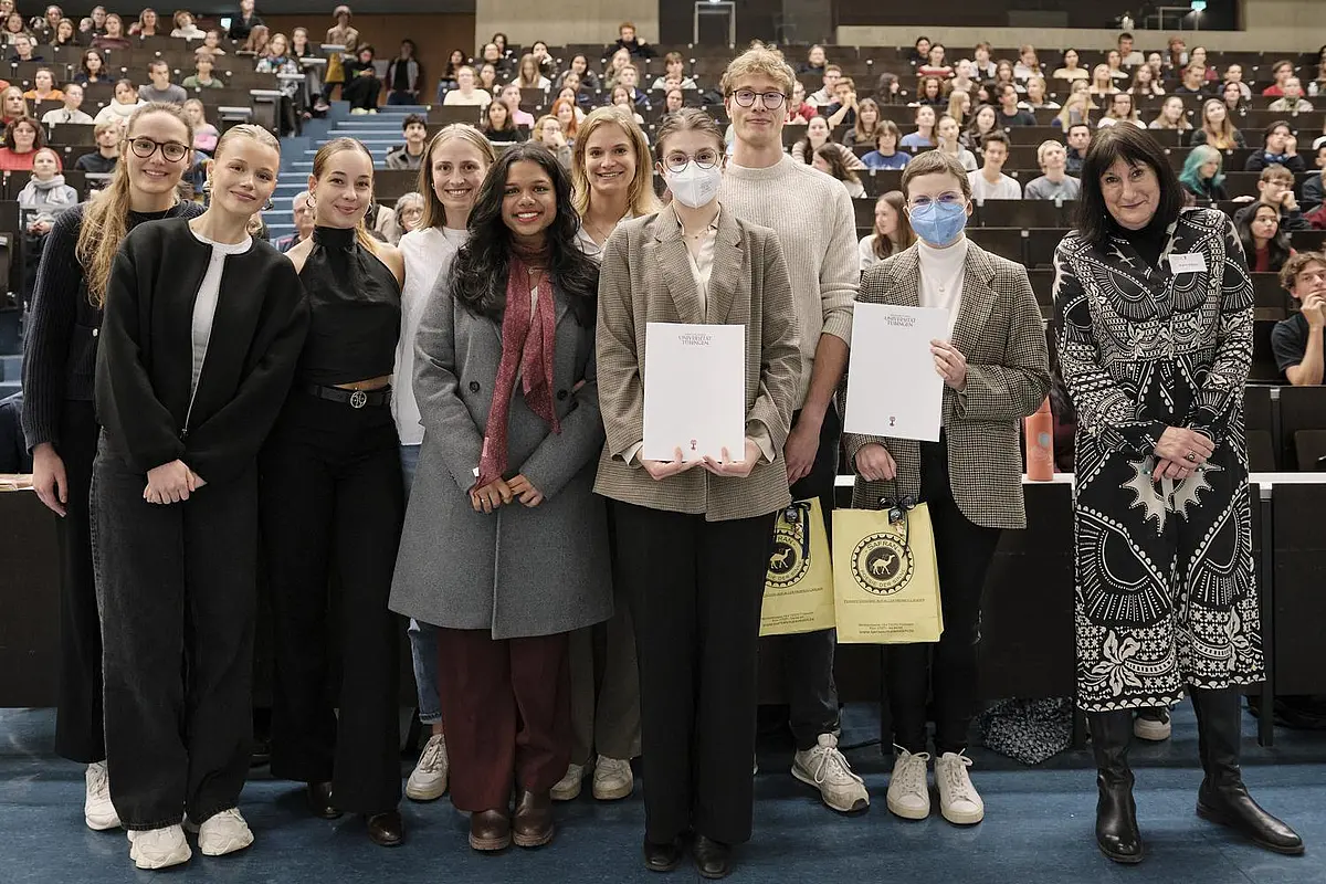 Gruppenbild der ausgezeichneten Studierenden mit Prorektorin vor vollbesetztem Hörsaal