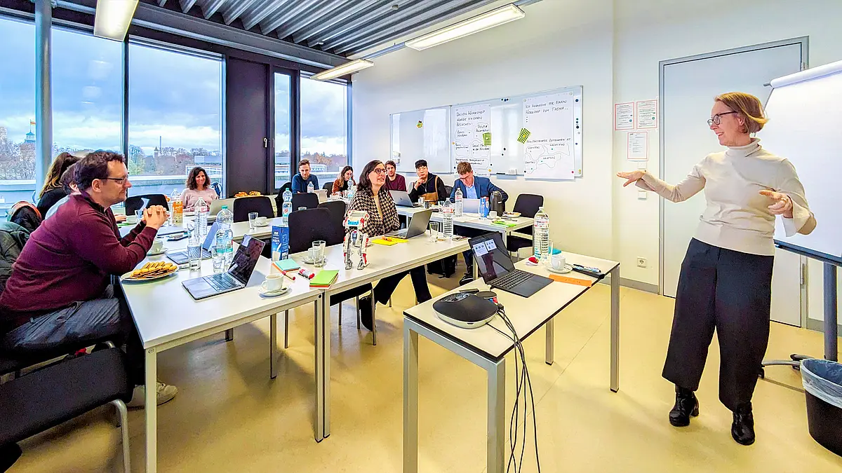 Frau steht in einer Seminarsituation vor einer Gruppe