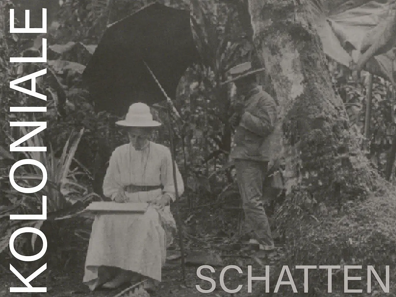 Schwarz-weiß-Foto von Elisabeth Krämer-Bannow, die unter einem Sonnenschirm vor Palmen sitzt und Skizzen macht