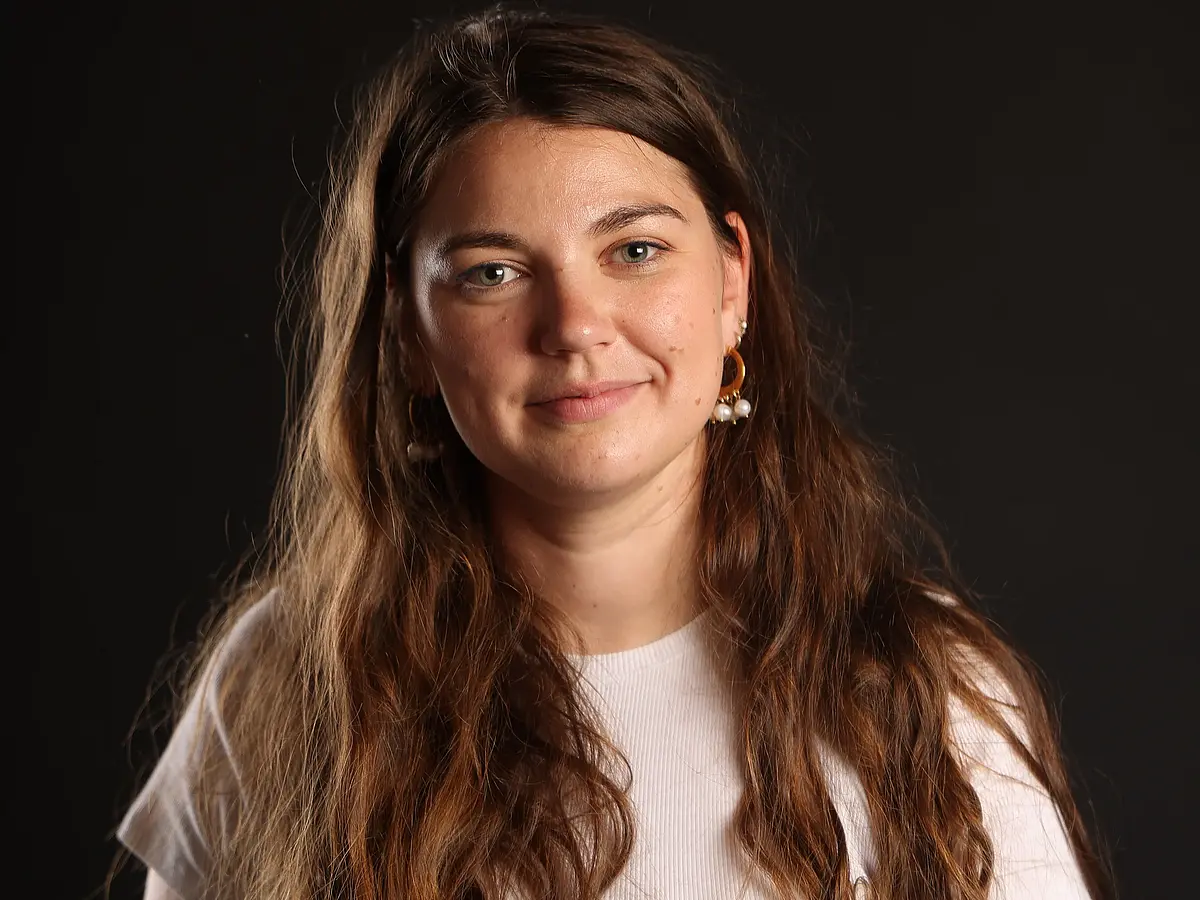 Headshot of Armelle Ballian against a black backdrop smiling into the camera.
