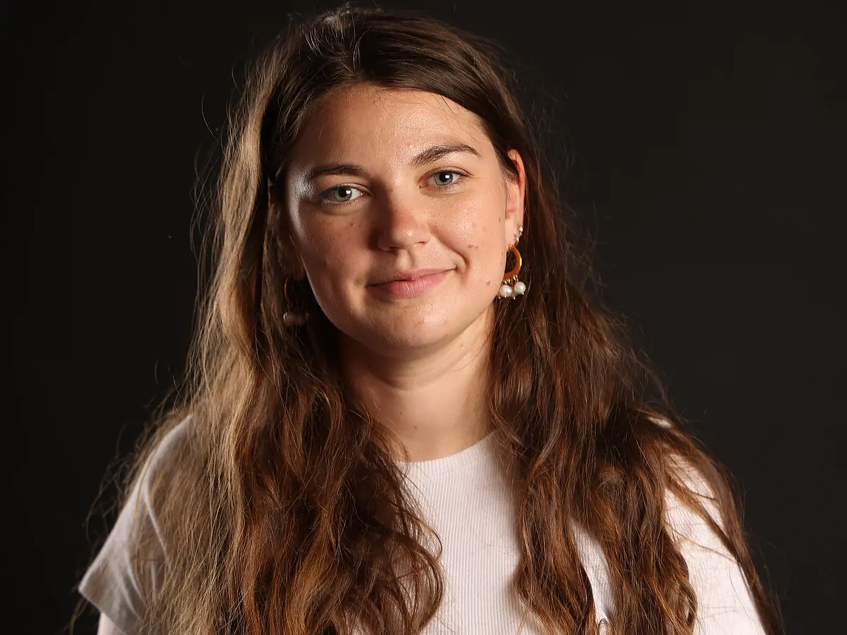 Headshot of Armelle Ballian against a black backdrop smiling into the camera.