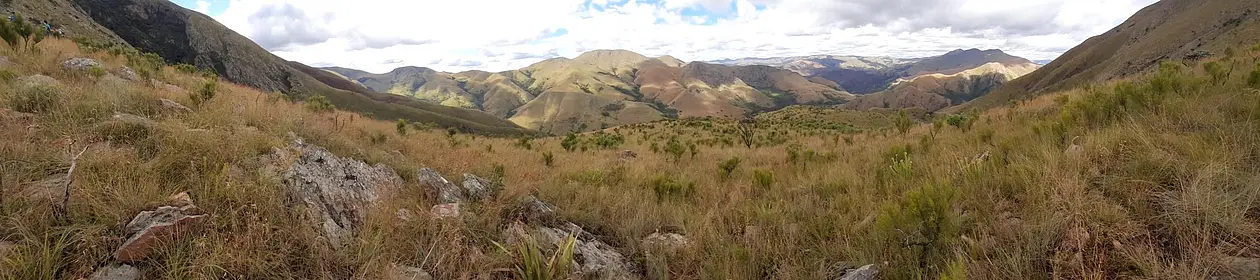 Photo of hilly landscape with rocks and grassland