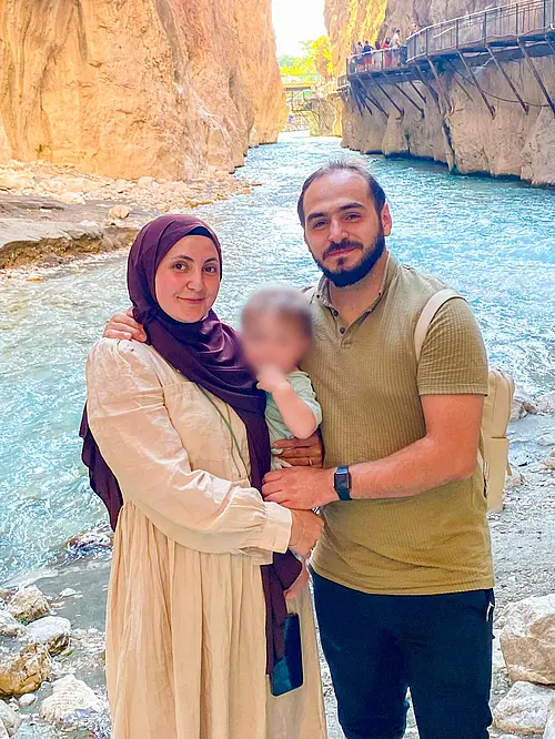 Tugba Colak mit Mann und Sohn bei einem Wochenendausflug im Saklıkent-Nationalpark. Im Hintergrund sind ein Fluss und Felsen zu sehen. 