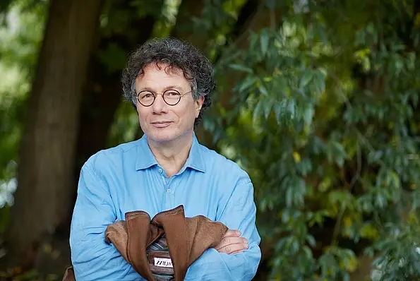 Foto von Ingo Schulze mit einer Jacke in der Hand