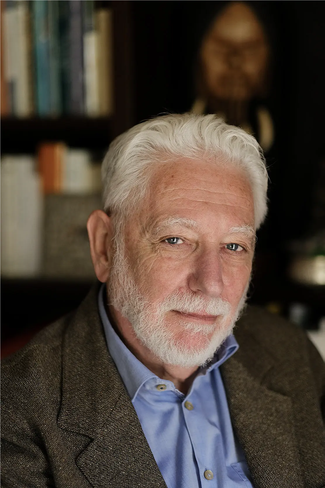 man with white hair and beard looking into the camera