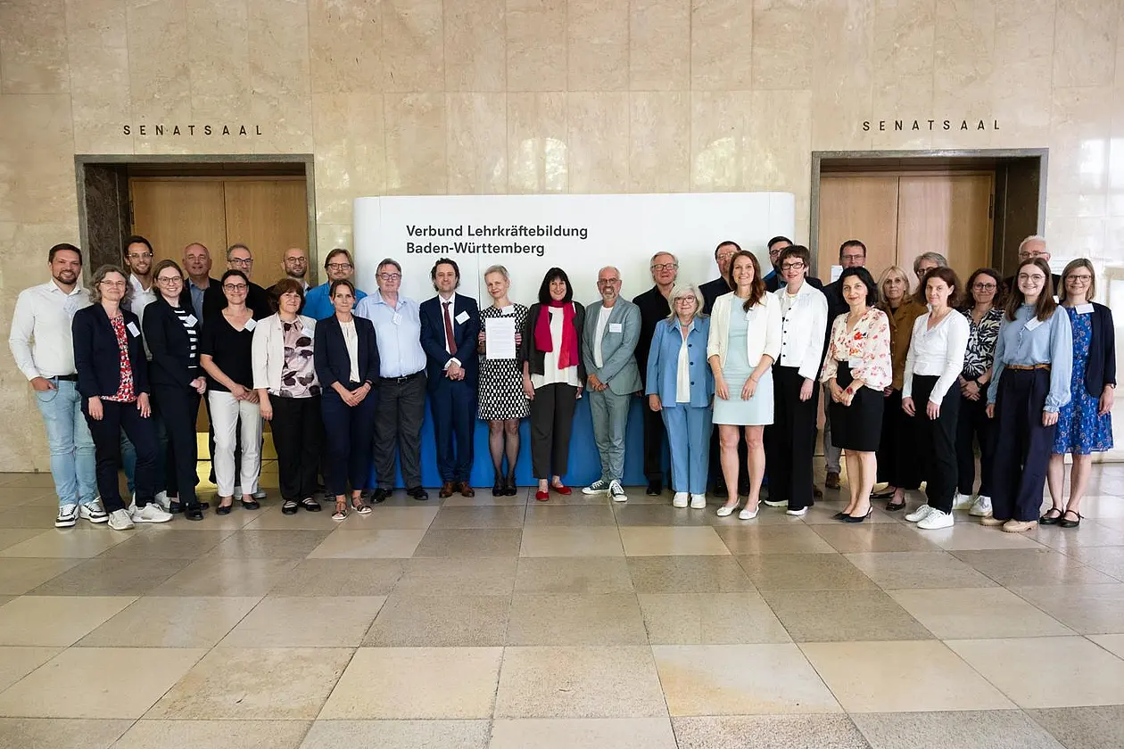 Gruppenfoto: rund 30 Personen vor einer Tafel mit der Aufschrift "Verbund Lehrkräftebildung Baden-Württemberg"