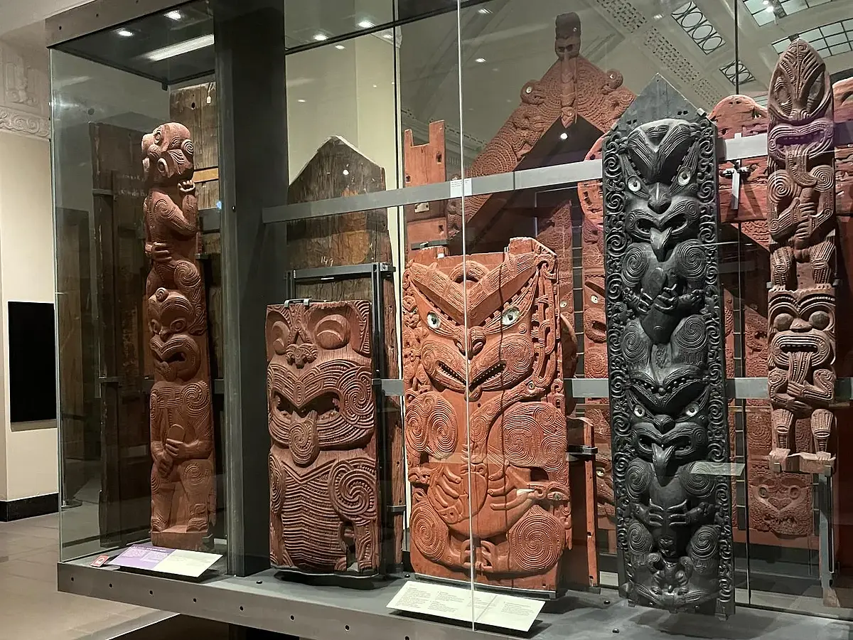 Geschnitzte Ahnendarstellungen in Glasvitrine