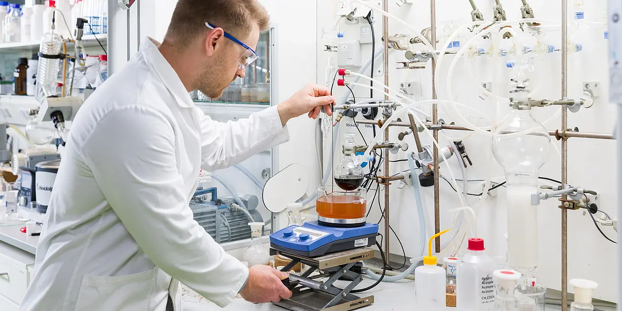 Ein Foto das einen Student beim Aufbau eines Experiments im Labor zeigt