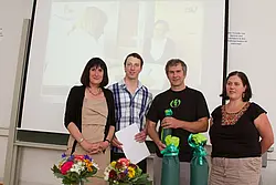 Patrick Holpp wurde der Preis für seinen Filmbeitrag „Rätselhaften Krankheiten auf der Spur“ überreicht. Unter der Leitung von Oliver Häußler (2. v. r.) berichtete Holpp für CampusTV von der Arbeit des Zentrums für seltene Erkrankungen.