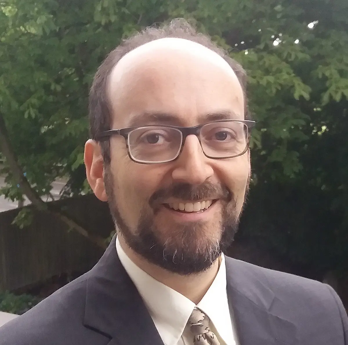 man with glasses and beard looks into camera