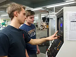Marcel Dewenter und Robert Meinecke beim Einstellen einer CNC-Maschine.