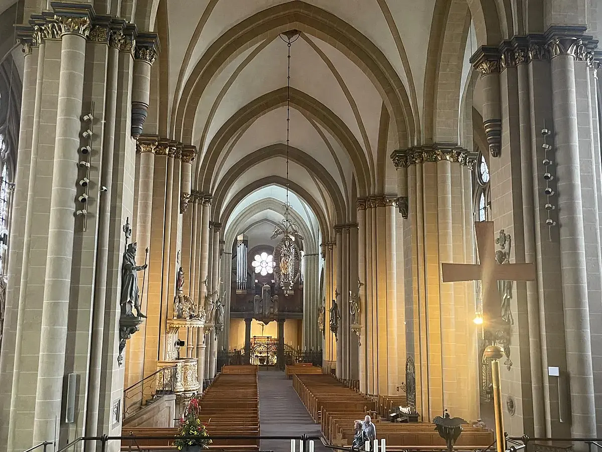 Auf dem Bild ist die Decke und der obere Teil eines Kirchenschiffs von Innen zu sehen. Es handelt sich um einen gotischen Baustil.