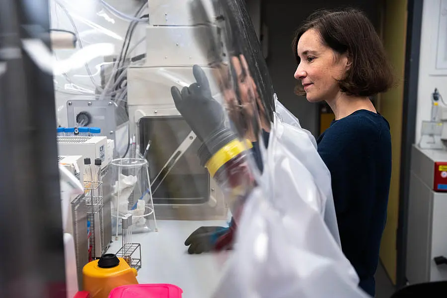 Photo of Lisa Maier working on an anaerobic chamber.
