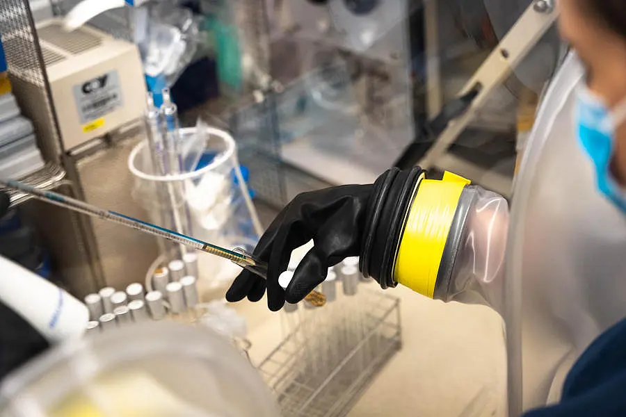 Close-up of a hand working on an anaerobic chamber.