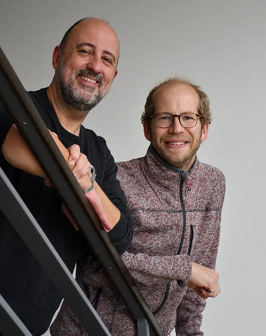Foto von Udo Kraushaar und Peter Jones an einem Geländer lehnend