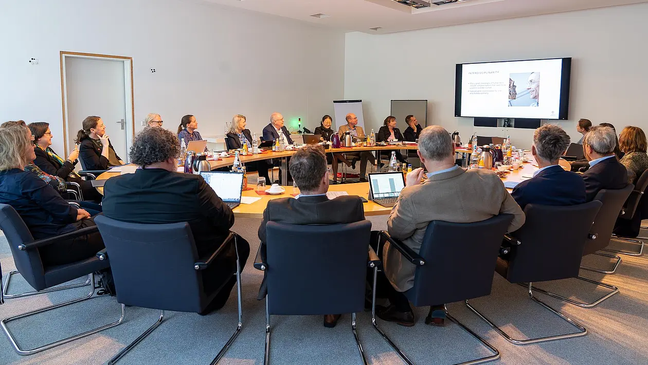 Gruppenfoto der Delegation um einen runden Tisch