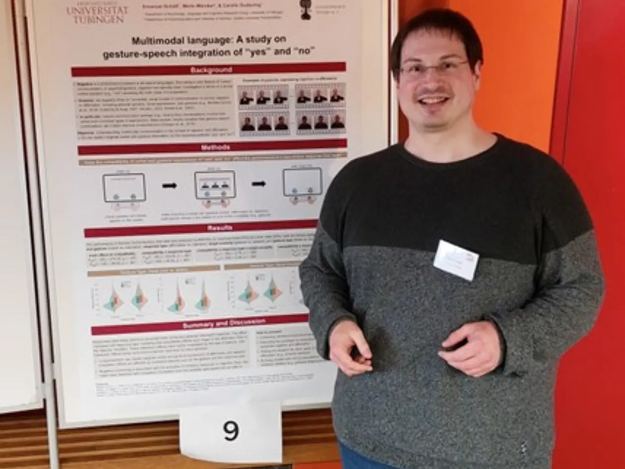 Bild zeigt Herrn Schütt vor seinem wissenschaftlichen Poster auf der Tagung
