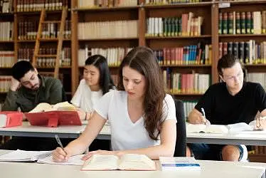 Studierende sitzen in der Bibliothek und lernen.