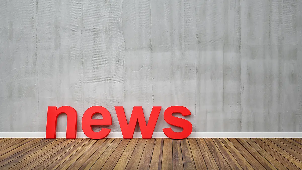 Foto von roten Buchstaben, die auf dem Boden vor einer Wand stehen und News buchstabieren