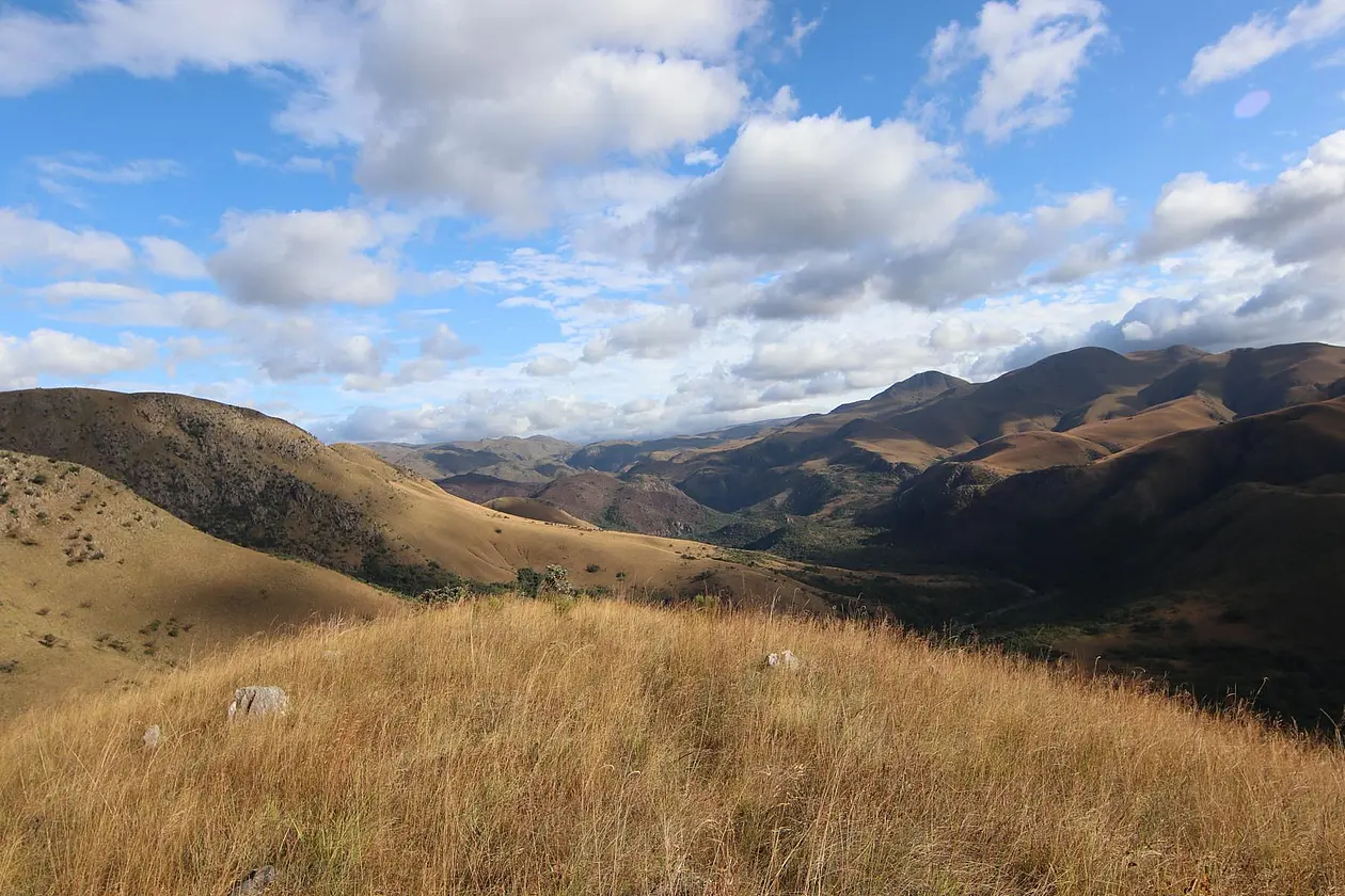 Photo of hilly landscape with rocks and grassland