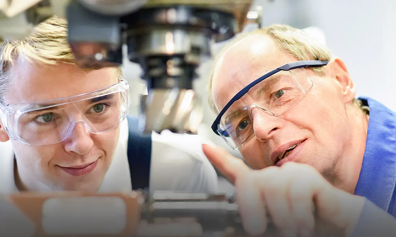 Ein Lehrer erklärt einem Schüler ein technisches Gerät