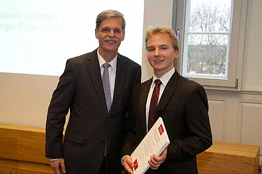 Rektor Prof. Bernd Engler mit einem von zwei Stipendiaten der Evangelisch-Theologischen Fakultät, Wolfram Theo Dünkel.