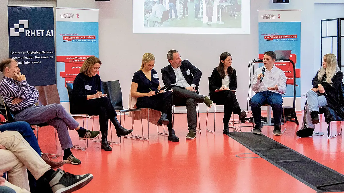 Menschen sitzen in einem Stuhlkreis mit der Wissenschaftsministerin von Baden-Württemberg und diskutieren. Bürgerrat KI und Freiheit