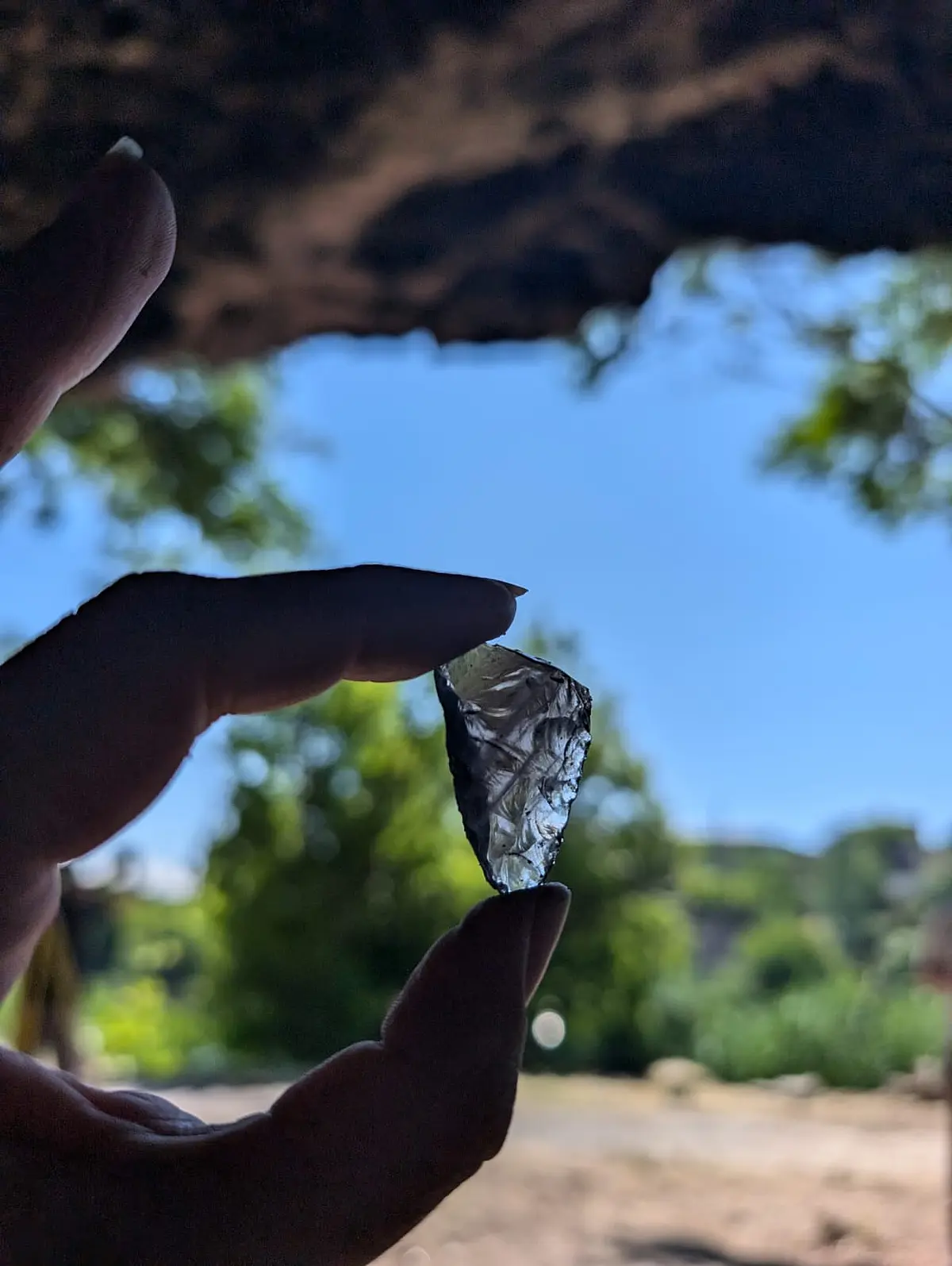 Obsidian-Splitter, der zwischen zwei Fingern gehalten wird