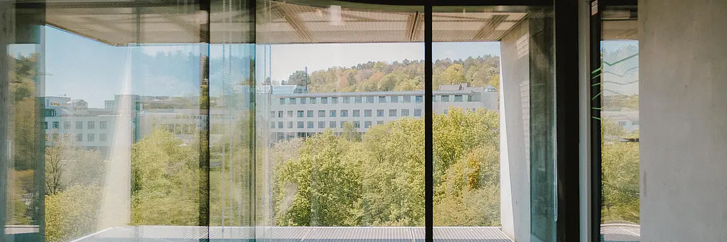 Fenster mit Blick auf draußen, dort steht ein Universitätsgebäude.