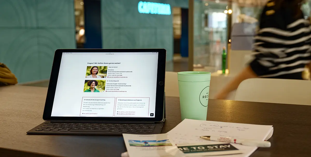 Blick auf einen Stehtisch mit Kaffeebecher und Tablet