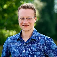 A male person in his mid-30s with blond hair and glasses