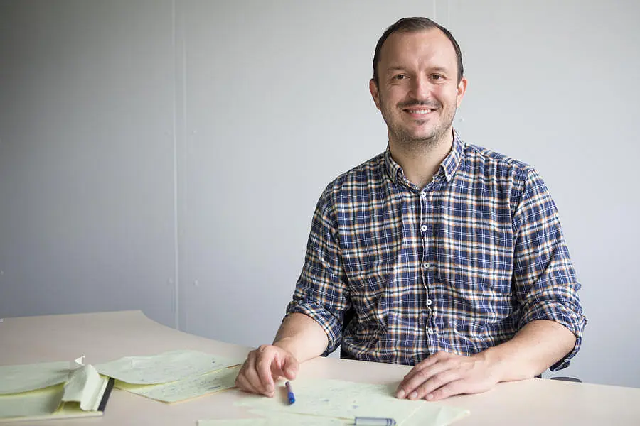 Foto von Professor Dr. Marius Lemm am Tisch sitzend