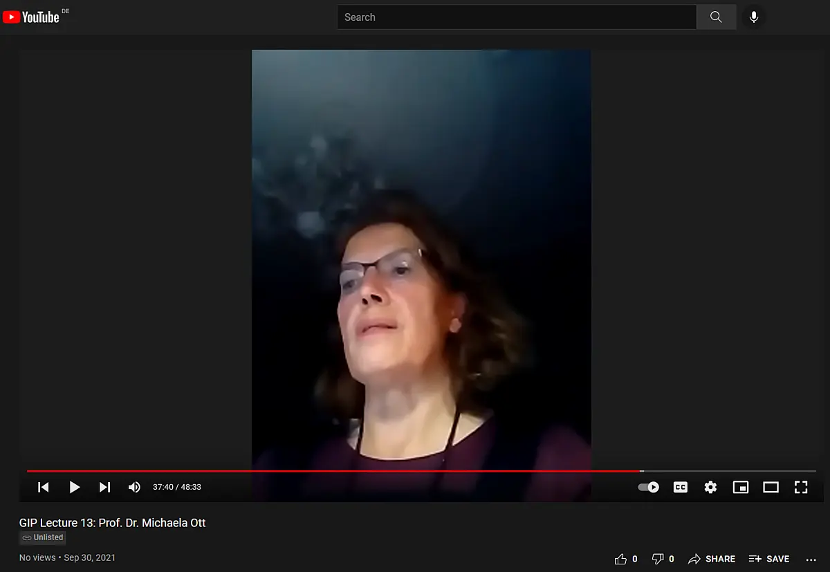 Woman against dark background talking into webcam