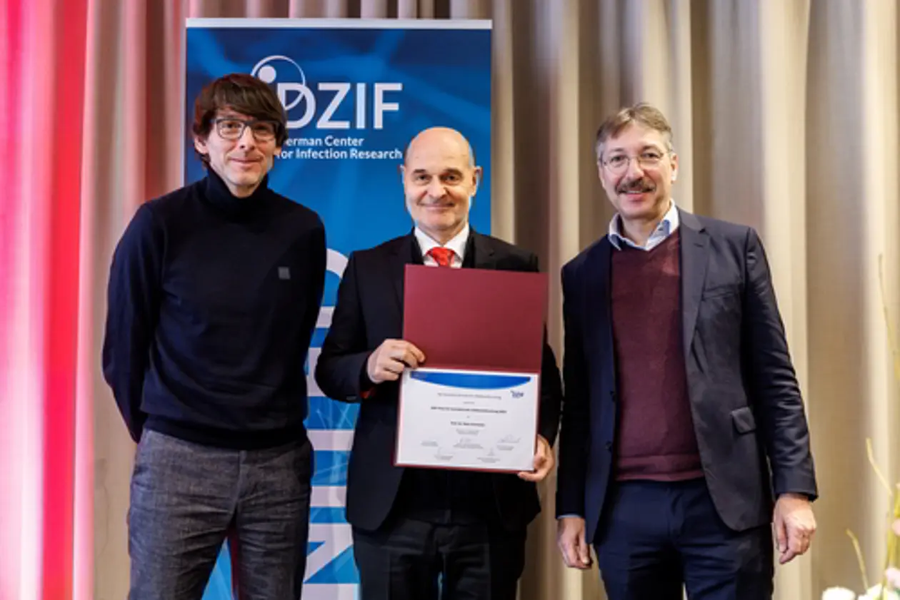 Prof. Peter. Kremsner (Mitte) erhält den DZIF-Preis für translationale Infektionsforschung 2024: Prof. Jan Rupp als Koordinator der DZIF Academy (links) und der DZIF-Vorstandsvorsitzende Prof. Dirk Busch (rechts) überreichen auf der gemeinsamen Jahrestagung von DGI und DZIF 2025 in München die Urkunde.