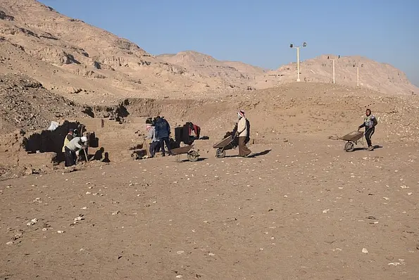Photo of a group of workers in the area where the ostraca are found. In the background, the hill of Athribis.