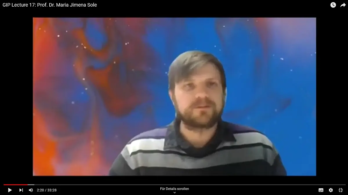 Man with brown beard looks into web-cam
