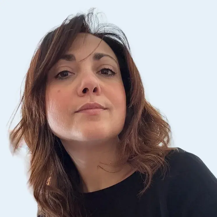 A Photo of Marianna Fusco, facing the camera from slightly above. She is a white woman with medium long phased brown hair, wearing a dark blue shirt.