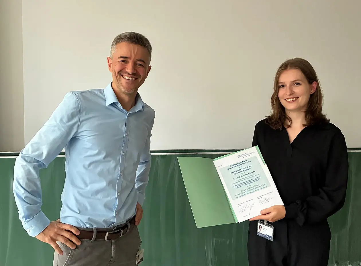 Samantha Kewitz steht neben Josef Leibold und präsentiert eine Urkunde.
