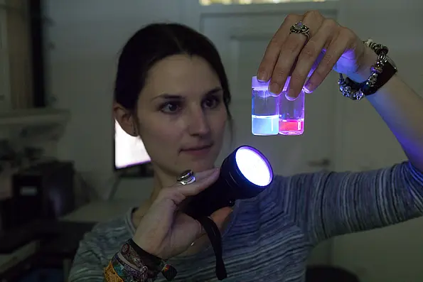 Elisabeth Kreidt veranschaulicht mit der Taschenlampe, wie die Lanthanoide durch Bestrahlung bei der Lumineszenzspektroskopie ausgelesen werden können.