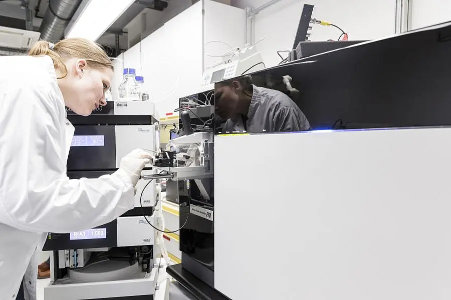 Eine Wissenschaftlerin arbeitet an einem Gerät im Labor
